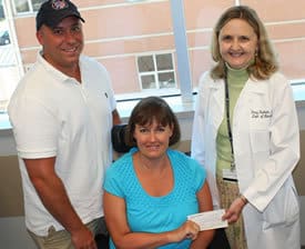 Tim and Debra Chaney of Mountain Home present a check to Stacy Rudnicki, M.D., for ALS Research at UAMS.