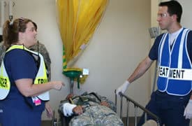 UAMS nurses Amy Niemann and Joe Fendley consult briefly after a patient reaches the triage area.  