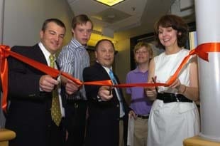Lisenne Rockefeller (far right) and sons John Alex and Lewis join Kent McKelvey, M.D., (left) and Bradley Schaefer, M.D., (center) in cutting a ribbon to open the new adult genetics clinic.