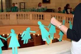 A string of paper dolls represents the 130 Arkansas women who died of ovarian cancer in 2008.