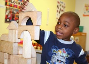 Carrington Cohens, a KIDS FIRST student, builds a tower. 