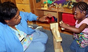 Bobbie Courtney, a 20-year early childhood development specialist at KIDS FIRST, plays with Claysha Beasley. 