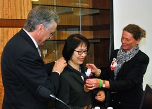 UAMS Chancellor Dan Rahn and College of Nursing Dean Claudia Barone present Tsai with her medallion. 