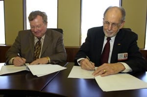 CHRP Dean Ronald Winters, Ph.D., (right) and Lyon College’s  John M. Peek formalize a partnership between the college and UAMS’ medical technology program.