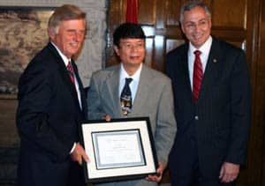 Arkansas Gov. Mike Beebe alongside Daohong Zhou, M.D. and UAMS Chancellor Dan Rahn, M.D.