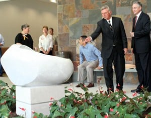 Gov. Mike Beebe joins UAMS Chancellor Dan Rahn tossing ceremonial tokens into the institute’s new Seed of Hope sculpture.