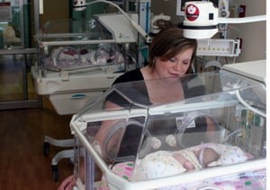 Web cameras above UAMS’ NICU isolettes help Paula Parnell (above) and her husband, Skip, of Jonesboro, stay connected to their twin newborns.   