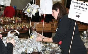 Longtime UAMS employee and volunteer Nancy Batie organizes a table of Aromatique products. 