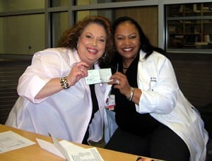 Ronda Henry-Tillman, M.D., (right) accepts a $43,000 donation for breast cancer screening, education and research from Bernice Nelms of Ashley County Cares.