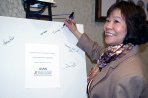 Jeanne Wei signs a ceiling tile that will be used in the expansion.