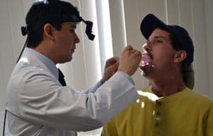 Mauricio Moreno, M.D., does a follow-up exam on Larry Massanet after successfully removing a tumor from his tongue. 