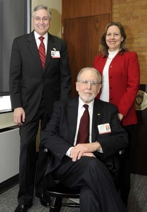UAMS Chancellor Dan Rahn, M.D., and Dr. Winters' wife, Marsha, pose with the dean sitting in the new chair sybolising his appointment as dean emeritus.