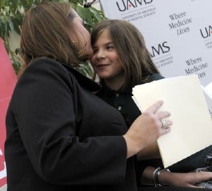 Helen Woodyard gets a kiss before her mom talks about the importance of philanthropy at UAMS.