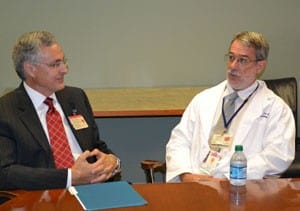 Paul L. Hermonat, Ph.D., professor of internal medicine in the Division of Cardiovascular Medicine of the College of Medicine and holder of the gifted chair, explains his research while UAMS Chancellor Dan Rahn, M.D., listens. 