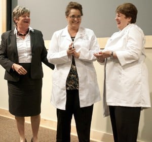 Carol Ellen Compas, R.N., in the nursing science doctoral program (center), receives her white lab coat from mentor Claudia Beverly, Ph.D., R.N., (left) and Elaine Souder, Ph.D., R.N., program director.