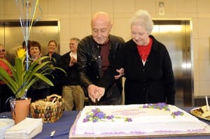Myeloma Institute founder and director Bart Barlogie helps patient Lillian Dameron slice a cake marking the institute treating its 10,000th patient.