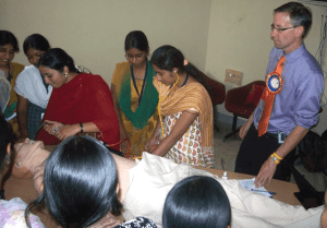 UAMS' Michael Manley (right) helped nursing students in Hyderabad, India learn how to train on a manikin.