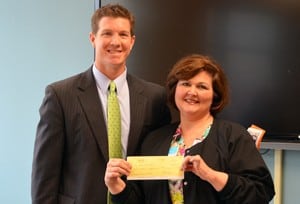 UAMS Family Home board chairman Greg Ramer presents a donation of $13,057 to neonatal intensive care nurse Shannon Hall, R.N.