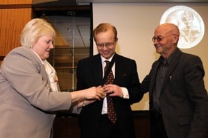 College of Medicine Dean Debra Fiser (left) and Myeloma Institute Director Bart Barlogie present the ceremonial medal to Fritz van Rhee.