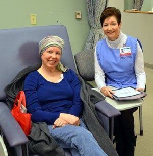 Volunteer Inez Stone (right) pauses while reading to patient Kay Tatum.