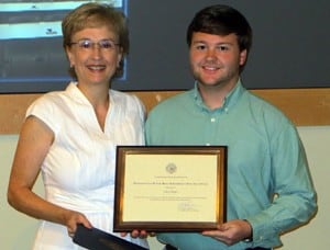 Melanie Reinhardt ’81/’08, assistant professor of Pharmacy Practice, presents Hayes with the award.