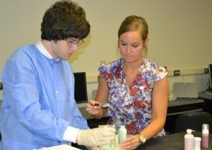 Andrea Mooney, a fourth-year pharmacy student, assists Ryan Anglin, a senior from Cabot, with aloe vera foam.
