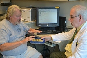 W. Steven Metzer, M.D., (right) performs the initial programming of Tommy Rickman’s deep brain stimulator.