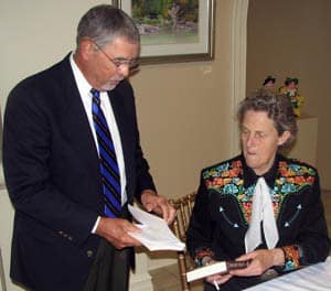 Temple Grandin autographs a copy of her book for Victor Jacuzzi, an honorary co-chair of the UAMS-sponsored luncheon where she was the guest speaker.