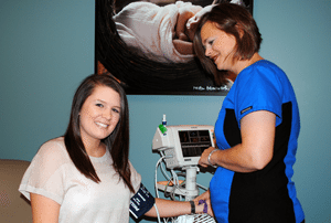 Sarah Holland (left), has her blood pressure checked by UAMS’ Shannon Wilson, R.N., as part of Holland’s routine pregnancy visit and as a participant in a UAMS-led autism study. 
