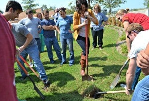 Medical students, including Teri Moak, center, dig in with their shovels before planting the tree they donated.