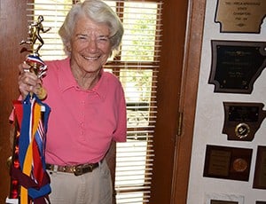 Shirley Pence, a patient of the Thomas and Lyon Longevity Clinic, holds a trophy, ribbons and medals from the marathons and runs in which she participated well into her 70s