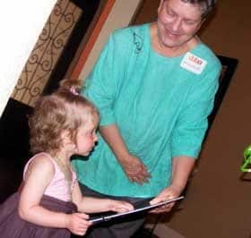 Michele Fox, M.D., presents Amelia Odle with a gift during a fundraiser for the Cord Blood Bank of Arkansas.  