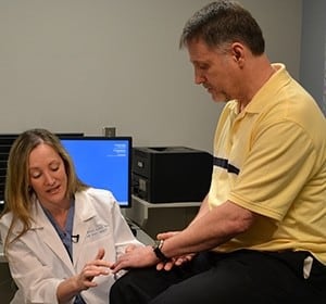Theresa Wyrick, M.D., examines Tommy Watts' left hand. Surgery performed by Wyrick helped save two of his fingers after an accident severely injured them.