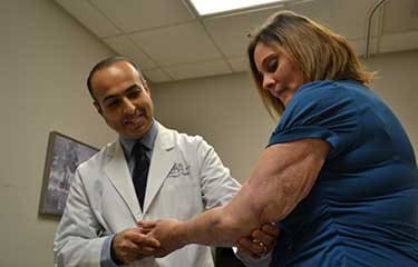 Shahryar Ahmadi, M.D., an orthopedic surgeon at UAMS, examines Lisa Shelton