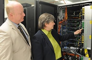 Jorden points to a data connection while discussing server technology with Thomas Powell, M.D., UAMS Medical Center chief medical information officer.
