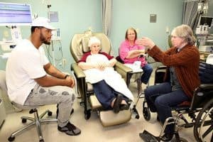 William Gholston of the Tampa Bay Buccaneers visits with melanoma patient Vada Adams and her daughters, Mitizi Garlington and Melanie Robertson.