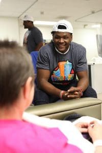 Demetrius Harris of the Kansas City Chiefs visits with a patient at the UAMS Cancer Institute.