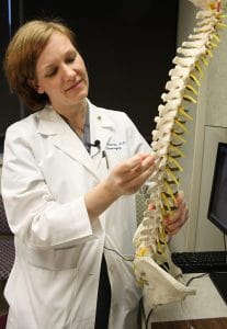 Erika Petersen, M.D. uses a spine model to demonstrate how the paddle-shaped electrode would go in the spinal canal. Petersen was one of the first four physicians to perform the procedure with the newly-approved Specify SureScan MRI surgical leads. 