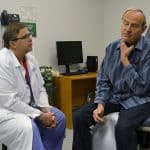 Robert Tunaitis shows Matthew Smeds, M.D., where his neck is tender following surgery to clear blockage from his carotid artery.