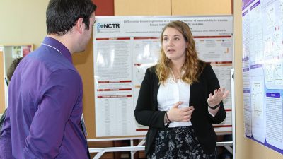 A student shows her research poster