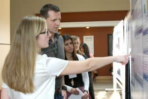 A student shows her research poster