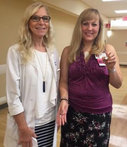 Debra Johnson, R.N., awards Marine Oats, R.N., an "I Saved a Brain" pin for her actions in getting Ricky Mays help after he had a stroke while visiting a UAMS patient.