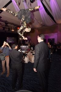 An acrobatic "human chandelier" poured champagne for guests while hanging upside down from the ceiling.