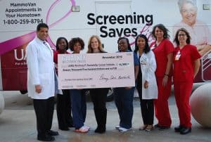 Penny Burkhalter of Gwatney Buick GMC (fourth from left) presents a donation to the UAMS MammoVan. Accepting the donation are (from left) Sharp Malak, M.D.; Carrie Cochran-Raglan; Shannon Strickland; Whitney Thomas; Gwendowlyn Bryant-Smith, M.D.; Crystal Smith; and Heather Buie.