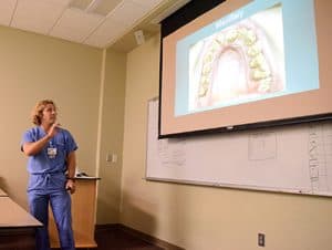 Dental resident William Wilson, D.D.S., shows pictures of the teeth of a patient he is treating for amelogenesis imperfecta, a disorder that affects tooth development. 