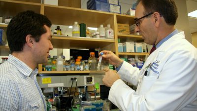 Professor and student look at sample