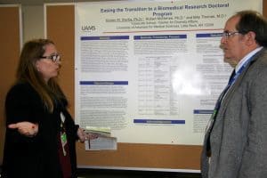 Professors in discussion before poster board