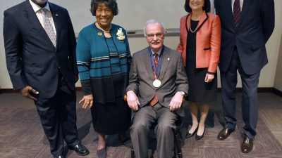 James M. Raczynski, Ph.D. (seated), dean of the UAMS College of Public Health, was named the inaugural holder of the M. Joycelyn Elders, M.D., Chair in Health Promotion and Disease Prevention. From left are former U.S. Surgeons General David Satcher, M.D., Ph.D., and M. Joycelyn Elders, M.D.; Stephanie Gardner, Pharm.D., Ed.D., UAMS senior vice chancellor for Academic Affairs and provost; and UAMS Chancellor Dan Rahn, M.D.