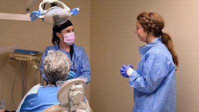 Bridget Fitzhugh, a dental hygiene student, and nursing student Kinsey Melton get ready to examine a patient’s teeth at the 12th Street Health & Wellness Center..