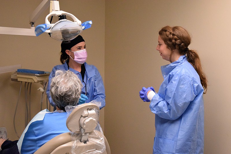 Bridget Fitzhugh, a dental hygiene student, and nursing student Kinsey Melton get ready to examine a patient’s teeth at the 12th Street Health & Wellness Center..